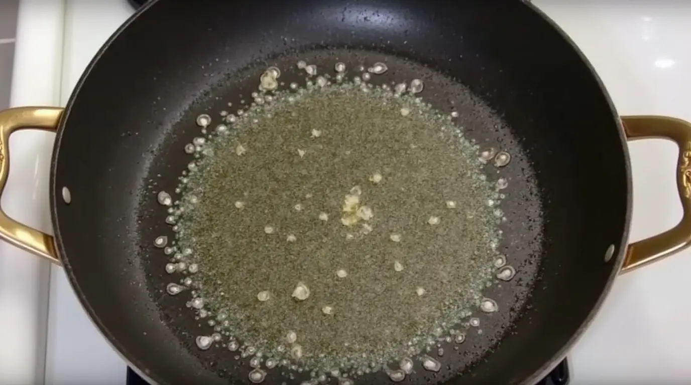 Poêle ou wok chauffé avec un peu d'huile à feu vif, prêt pour faire sauter les ingrédients