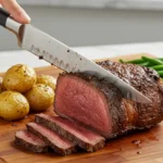 Découpe d’une côte de bœuf au four avec garnitures.