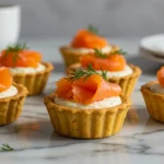 Tartelette au saumon fumé sur pâte dorée, garnie de saumon et d’aneth sur fond marbré moderne