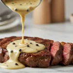 Côte de bœuf nappée d’une sauce au poivre crémeuse, en gros plan.