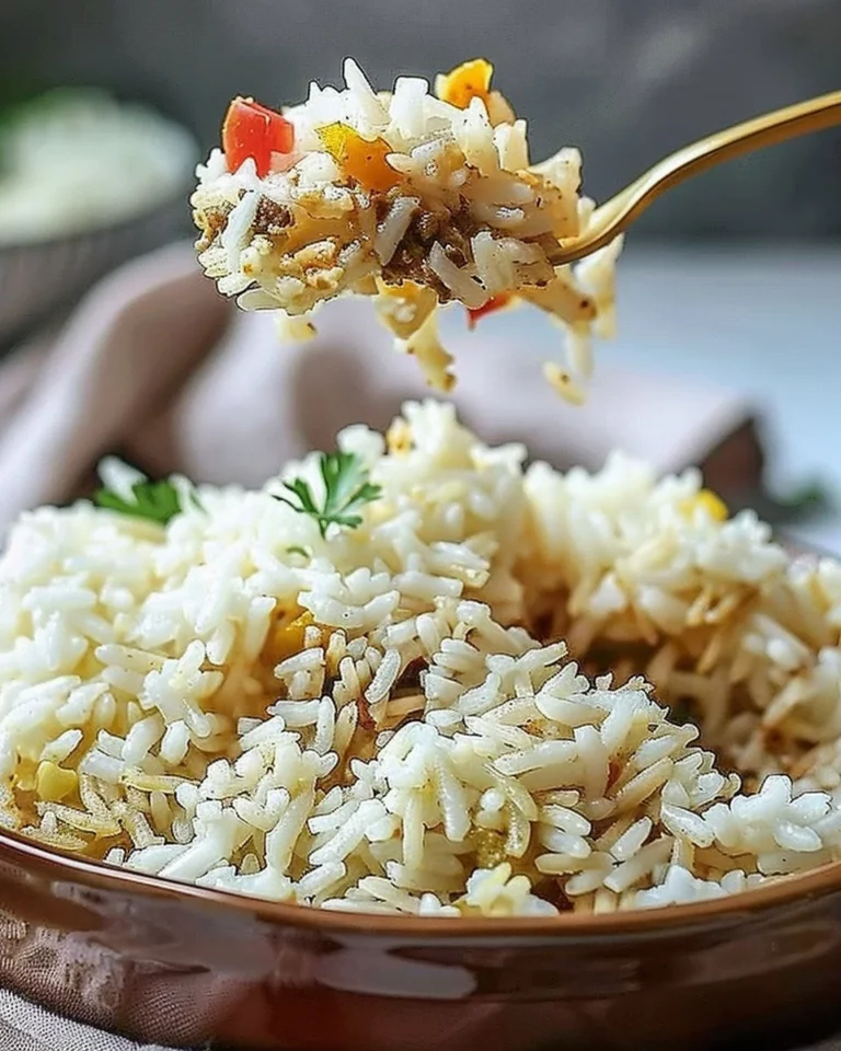 Bol de riz blanc préparé avec des légumes colorés et des épices.