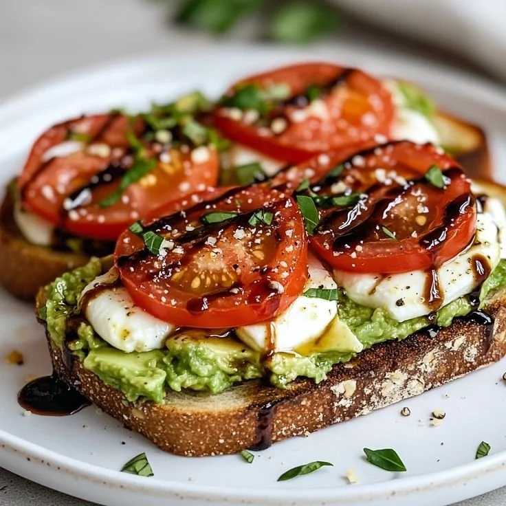 Toast à l'avocat Caprese garni de mozzarella, tomates et balsamique.