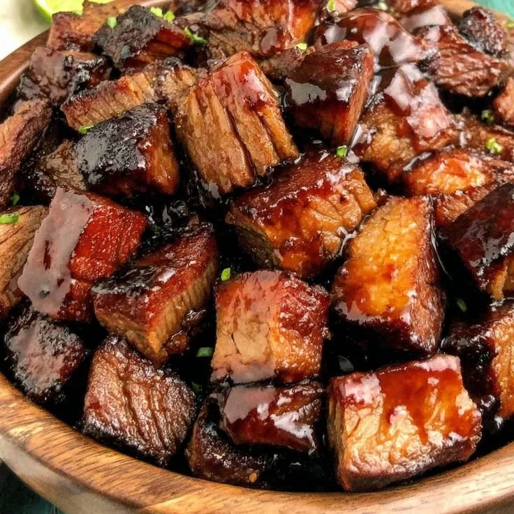 Morsels de brisket délicatement enrobés de sauce bourbon servies dans une assiette