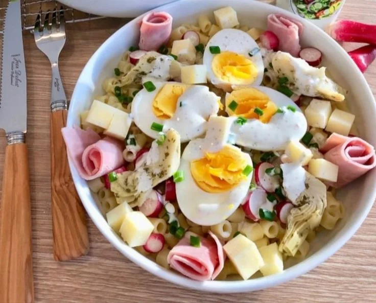 Salade de pâtes parisienne servie dans un bol avec légumes colorés.