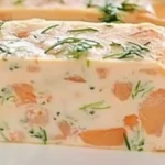 Terrine de saumon frais garnie de câpres et d'herbes, présentée sur une assiette.