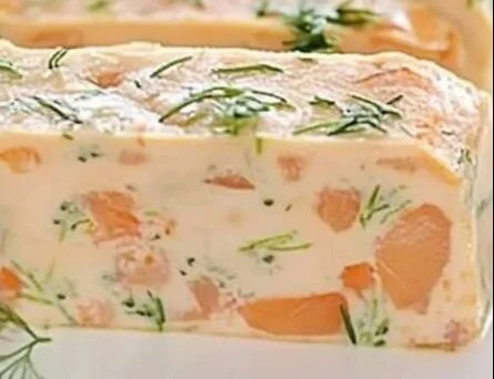 Terrine de saumon frais garnie de câpres et d'herbes, présentée sur une assiette.
