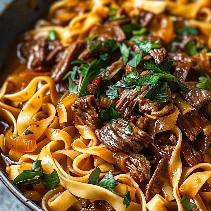 Une assiette de nouilles au bœuf savoureuse, garnie de légumes colorés.