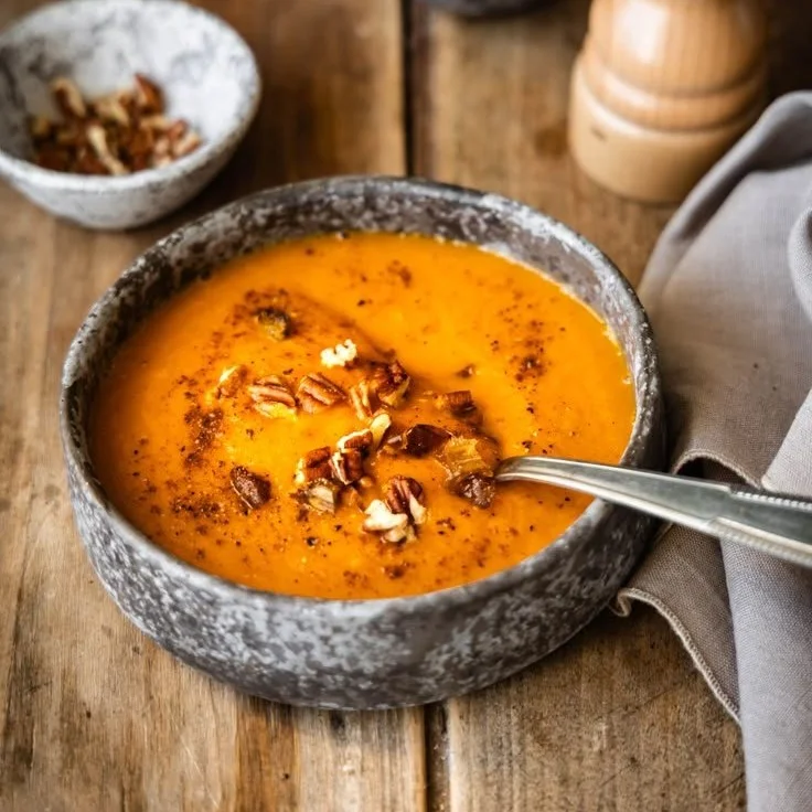 Soupe indulgente avec citrouille, carottes et patate douce dans un bol.